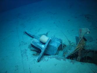 Stbd anchor embedded in steel plate from ship's side in debris field